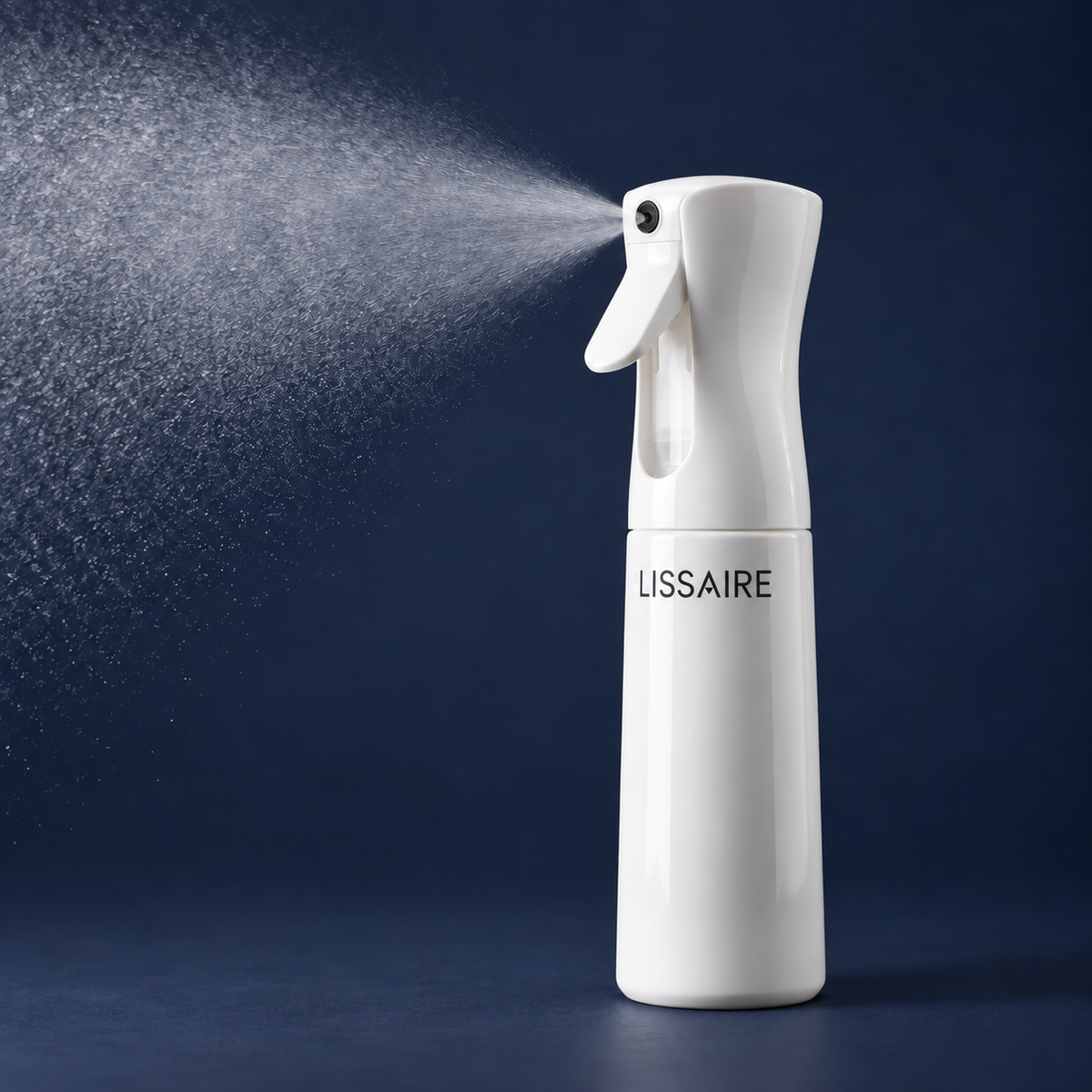 White Lissaire Auto-Mister spray bottle releasing a fine mist on a navy background