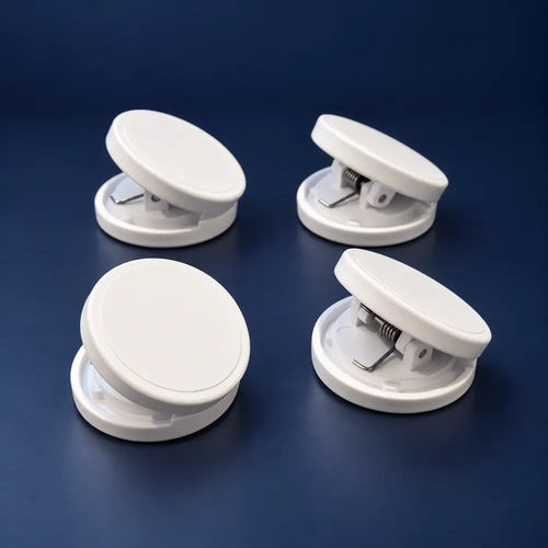 Four white round Crease-Lock weighted clips on a navy background